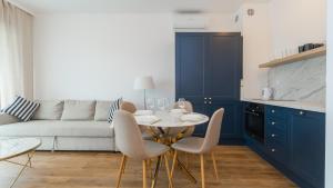 ein Wohnzimmer mit einem weißen Sofa, einem Tisch und Stühlen in der Unterkunft Apartamenty Sun & Snow Baltic Twins in Sztutowo