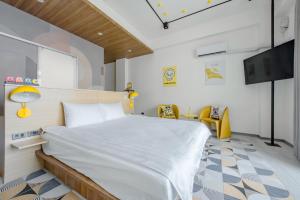 a bedroom with a bed and a flat screen tv at Long Stay Here in Tainan