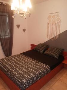 Schlafzimmer mit einem Bett und einem Kronleuchter in der Unterkunft The happy house in Le Martinet