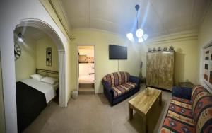 a bedroom with a bed and a couch and a chair at Panorama rooms in Chios