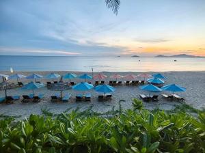 a group of umbrellas and chairs on a beach at Sea’lavie Boutique Resort & Spa in Hoi An