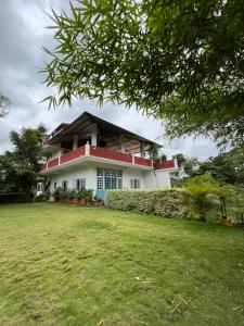 a house with a lawn in front of it at Manas Jungle Retreat in Jyoti Gaon