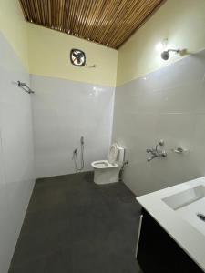 uma casa de banho com um WC e um lavatório em Manas Jungle Retreat em Jyoti Gaon