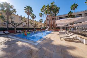 a pool at a hotel with palm trees at Estival Park Almaris in La Pineda