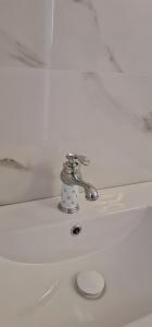 un lavandino bianco nel bagno con rubinetto d'argento di Luxury Rooms a Santa Teresa di Gallura