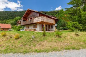a house sitting on top of a lush green field at Chalet L'oréade in Manigod