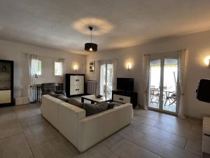 a living room with a couch and a table at La Villa Pavilou in Le Lavandou