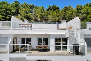 Una casa blanca con escaleras en la parte superior. en Real de Ifach - Atico, en Empedrola