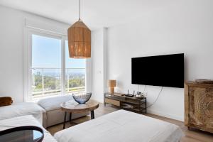 Una sala de estar con un sofá y un televisor en Real de Ifach - Atico, en Empedrola