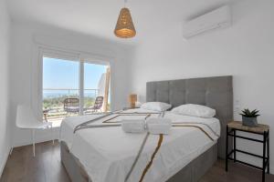 Un dormitorio con una cama grande con vista al mar. en Real de Ifach - Atico, en Empedrola
