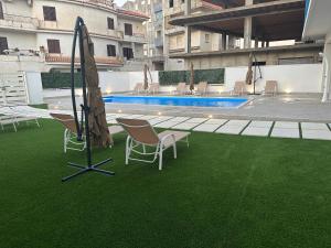 un patio con sillas, una sombrilla y una piscina en Casa Vacanze Giorgia, en Cirò Marina