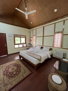 a bedroom with a large bed and a rug at Manas Jungle Retreat in Jyoti Gaon