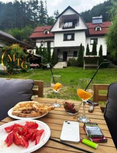 una mesa con un plato de comida y copas de vino en Montagnoli Luxury Villa en Cluj-Napoca