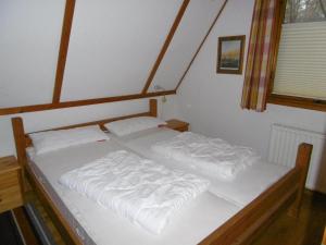 two beds in a bedroom with white sheets at Twistesee 36 in Bad Arolsen