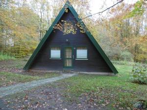 a black house with a pointed roof in the woods at Twistesee 36 in Bad Arolsen