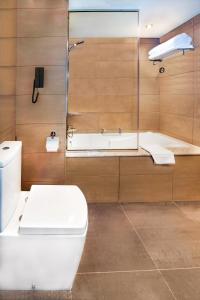 a bathroom with a toilet and a bath tub at Le Meridien Abu Dhabi in Abu Dhabi