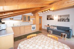 eine Küche und ein Wohnzimmer mit einem Sofa und einem Tisch in der Unterkunft Appartement Alpina in Alpbach