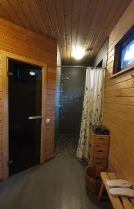 ein Bad mit einer Dusche und einer Tür mit einem Duschvorhang in der Unterkunft Sauna2relax in Šveicarija