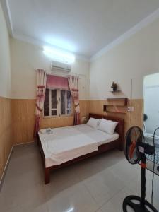 a bedroom with a large bed with a window at Tuan Thanh Homestay in Tân Hiệp