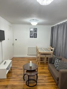 a living room with a couch and a table at T Lodge in Abbey Wood