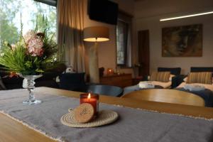 a table with a candle and a vase of flowers at Pokój kapitański in Polańczyk +19 photos