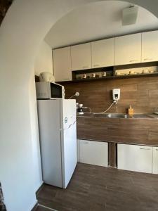 a kitchen with a white refrigerator and a sink at Къща за гости Ива 