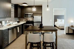 a kitchen with a table and chairs and a bed at Residence Inn by Marriott Harrisburg North in Harrisburg