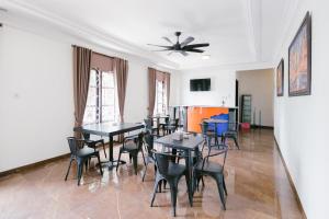 a dining room with black tables and chairs at Urbanview Hotel Sultan Palace Malang by RedDoorz in Dau