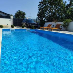 una gran piscina azul junto a una casa en Villa Ritual, en Mostar