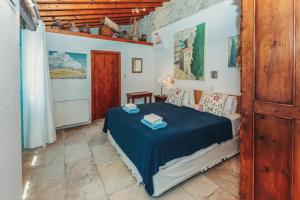 ein Schlafzimmer mit einem Bett mit einer blauen Decke in der Unterkunft Archondia House - Holiday Apartments With Pool in Kalavasos