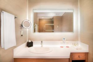 a bathroom with a white sink and a mirror at Le Meridien Abu Dhabi in Abu Dhabi