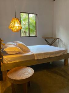 Bett in einem Zimmer mit einer Lampe und einem Fenster in der Unterkunft Kirãmam Villa in Pasikuda