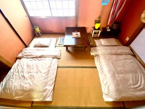 um quarto com 2 camas, uma secretária e uma mesa em 星ノソラ em Shodoshima