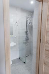 uma casa de banho com uma cabina de duche em vidro e um lavatório. em ALOFT em Kazbegi