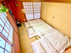 ein kleines Zimmer mit 2 Betten und einem Fenster in der Unterkunft 星ノソラ in Shodoshima