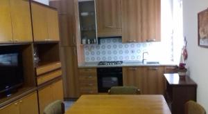 a kitchen with wooden cabinets and a table with chairs at Vista Super in Camerano Casasco