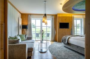 a living room with a bed and a couch at Wellness & Naturresort Reischlhof in Wegscheid +105 photos