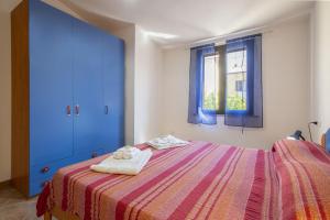 a bedroom with a bed and a blue door at Bilocale 1 medio Trinita' D'agultu in Trinità d'Agultu e Vignola