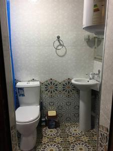 a small bathroom with a toilet and a sink at Гостевой дом AL XALIL in Samarkand