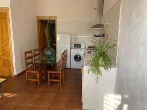 a kitchen and dining room with a table and a washing machine at Apartamentossierradegata La Noguera villamiel in Villamiel