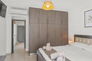 sypialnia z łóżkiem i dużą drewnianą szafką w obiekcie Rhodian Filoxenia w mieście Rodos