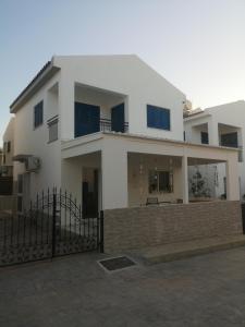 a white house with a fence in front of it at Efterpis12 St. House in Paralimni