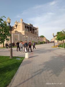 um grupo de pessoas andando em frente a um edifício em Гостевой дом AL XALIL em Samarkand
