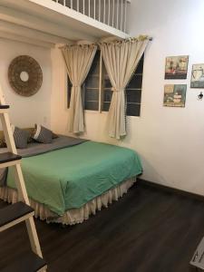 een slaapkamer met een groen bed en een raam bij Lily hostel in Ho Chi Minh-stad