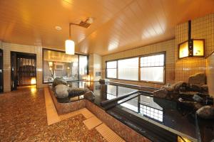 a teddy bear sitting on a bench in a building at Dormy Inn Obihiro in Obihiro