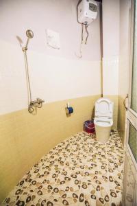 a bathroom with a toilet and a tiled floor at Mộc House in Mộc Châu