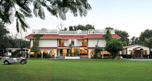 uma casa com um carrinho de golfe em frente em Best Western Resort Country Club em Gurgaon
