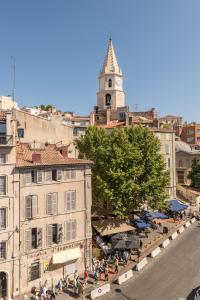 uma cidade com uma torre de relógio e pessoas sentadas em torno de uma rua em Splendide vue sur ND de la Garde et le Vieux Port em Marselha