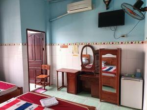 a room with a bedroom with a desk and a mirror at Khách sạn Ngọc Mai 2 in Can Tho