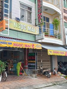 un homme debout devant un centre commercial nogoco dans l'établissement Khách sạn Ngọc Mai 2, à Cần Thơ
